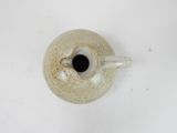 a white vase with a black spot in it