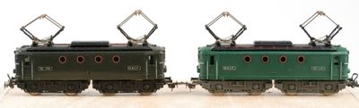 two toy trains sitting side by side on a wooden table