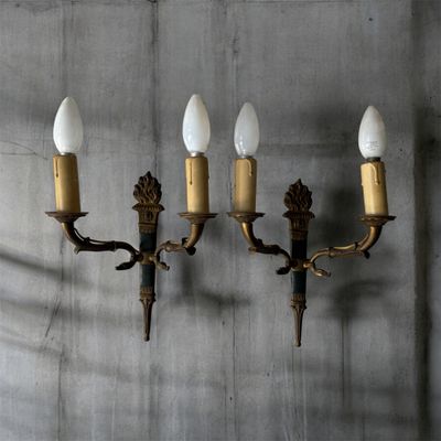 quatre appliques murales fixées sur un mur en béton dans une pièce