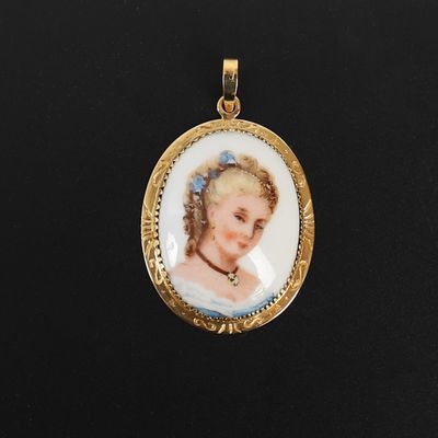 un gros plan sur la photo d'une femme figurant sur un pendentif plaqué or