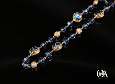 un gros plan d'un collier bleu et or sur fond noir