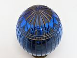 a blue glass bowl with a gold rim on a white surface