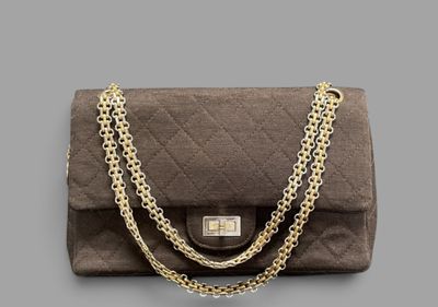 a close up of a brown purse with a chain around it