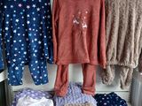three sets of pajamas hanging on a rack in a room