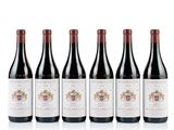 quatre bouteilles de vin sont alignées sur une surface blanche