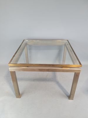 une table basse en verre et en laiton sur fond blanc