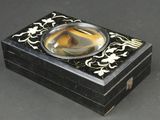 une petite boîte noire contenant un verre