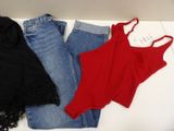 three pairs of jeans and a tank top sitting on a white surface