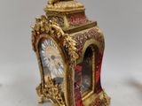 a gold clock with a cheren on top of it