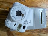 a white camera sitting on top of a wooden table
