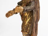 an old wooden statue of a man holding his hands out