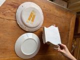 a person that is holding a piece of paper near some plates