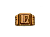 un gros plan d'une bague en or sur laquelle figure la lettre « l »