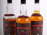 three bottles of whiskey sitting next to each other on a table