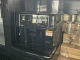 a black coffee machine sitting on a counter in a kitchen