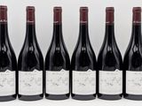six bottles of red wine are lined up in a row