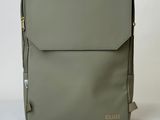 a grey backpack with a gold logo on the front
