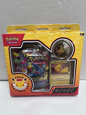 the box contains a pokemon trading card and a pokemon watch