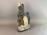 a figurine of a man riding a horse with two children