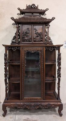 une grande armoire en bois munie d'une porte vitrée