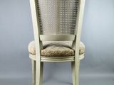 the back of a white chair with a beige seat