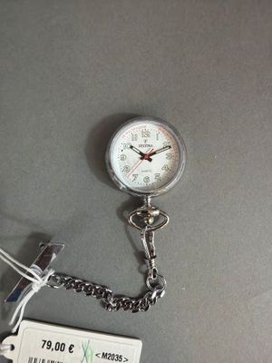 une montre à gousset en argent à laquelle est attachée une chaîne
