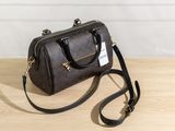 a brown handbag sitting on top of a wooden table next to a wall