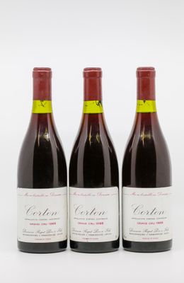 trois bouteilles de vin rouge posées sur une table blanche