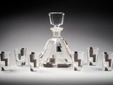 une carafe en verre entourée de nombreux verres à shot