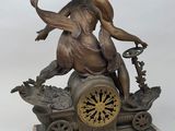 a statue of a woman riding a carriage with a clock on it