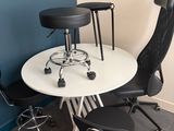 a white table with black chairs and a white table with a black chair