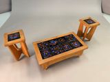 three wooden tables and two stools with blue and orange designs on them