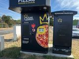 a black box with a pizza on it next to a road