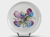 a white plate with a painting of a flower on it