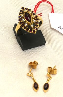 pair of gold tone earrings with garnets and a red string