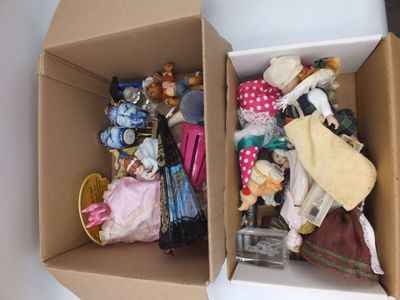 deux boîtes contenant des poupées, posées sur une table