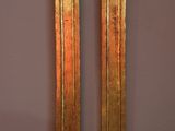 pair of antique brass clock faces on a pink wall