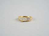 une bague en or jaune sertie de trois diamants sur fond blanc