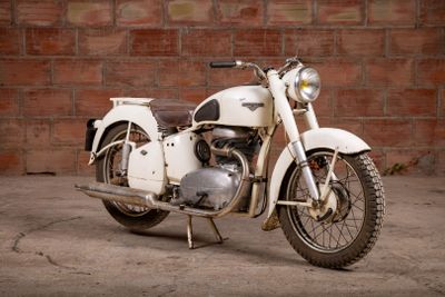a white motorcycle that is parked in front of a brick wall