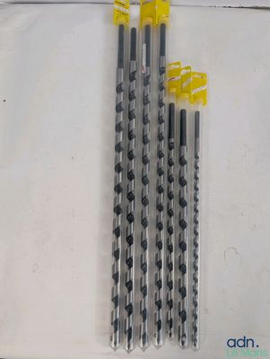quatre crayons noirs et blancs sont alignés sur une surface blanche