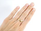 a woman ' s hand with a gold ring on it
