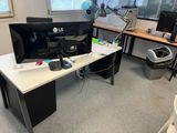a desk with a computer monitor and a printer on it