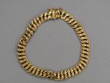 a close up of a gold bracelet on a gray surface
