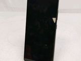 the back of a black cell phone sitting on top of a white table