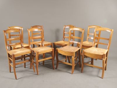 six chaises en bois sont alignées en rang contre un mur gris