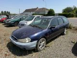 a blue car parked in a lot with other cars in the background