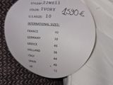 a price tag on a white umbrella on a brown chair