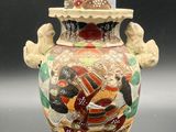a vase that has a bird on top of it