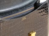a black purse with gold handles sitting on a table