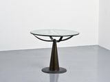 une table en verre avec un piètement en métal dans une pièce blanche